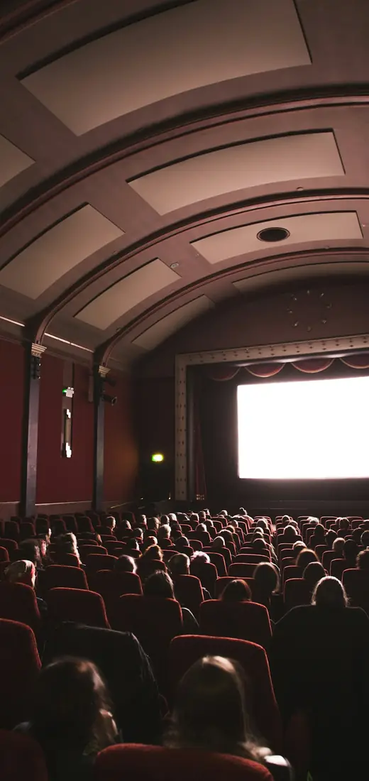 Sala de cine con el público frente a la pantalla, vista en el celular