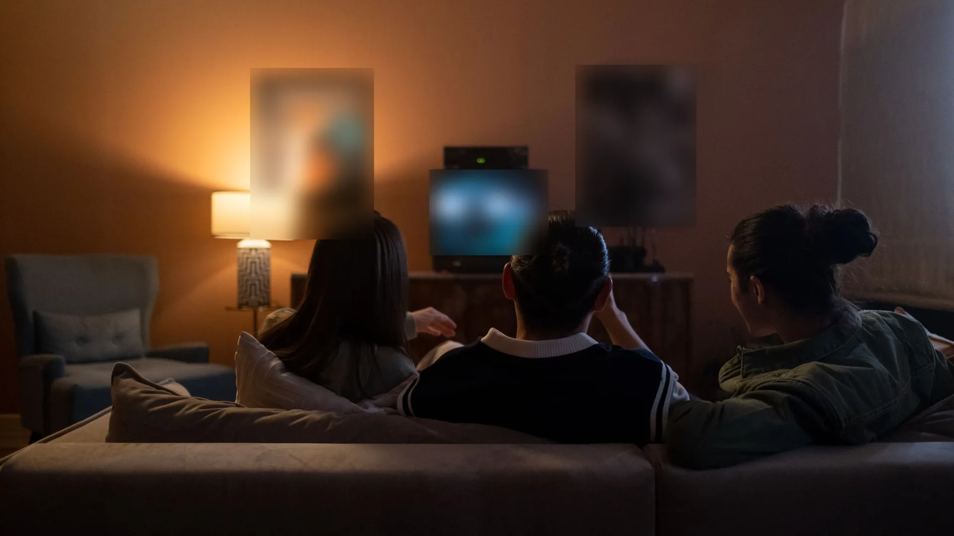 Tres amigos en un sofá viendo la tele de noche en la sala