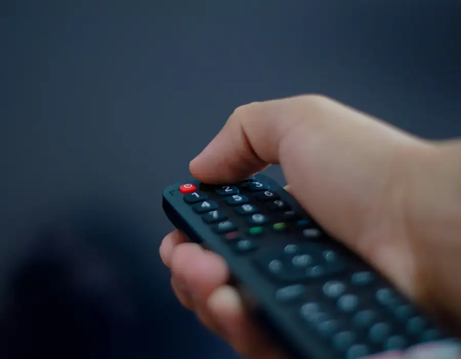 Mano con el control remoto apuntando a la tele