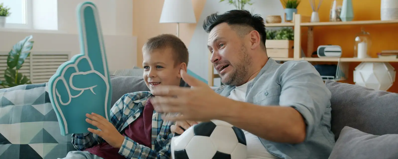 Padre e hijo en el sofá viendo un partido en la tele
